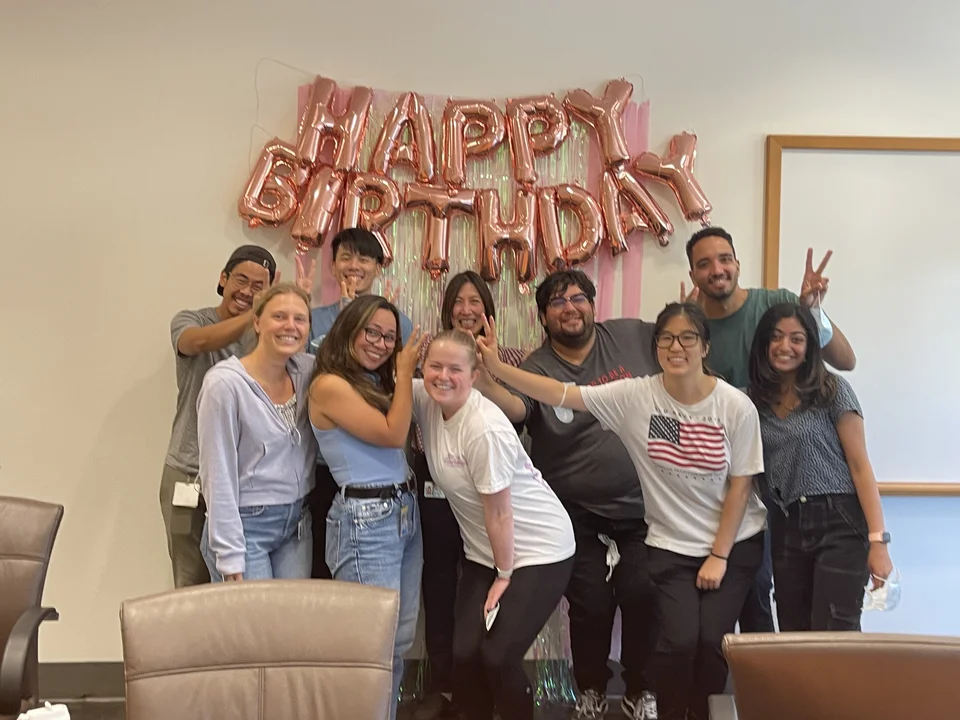 Group posing in front of 'Happy Birthday' banner
