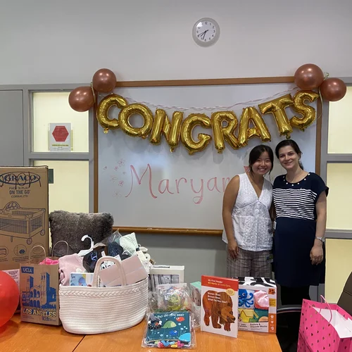 Two lab members standing together in front of 'Congrats' banner